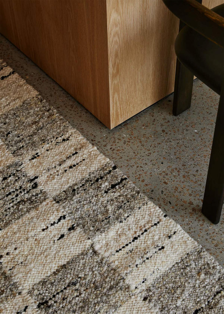 The Trube Hoome NZ Harvest natural wool rug seen close up on the floor next to a chair