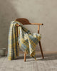 The Weave Home nz Brighton Butter throw seen in a modern setting draped over a chair, showing off the sunny yellow paid design