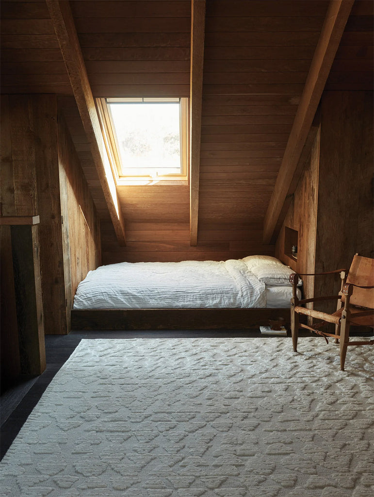 A stylish attic room featuring the Tribe Home nz cream Husky wool rug